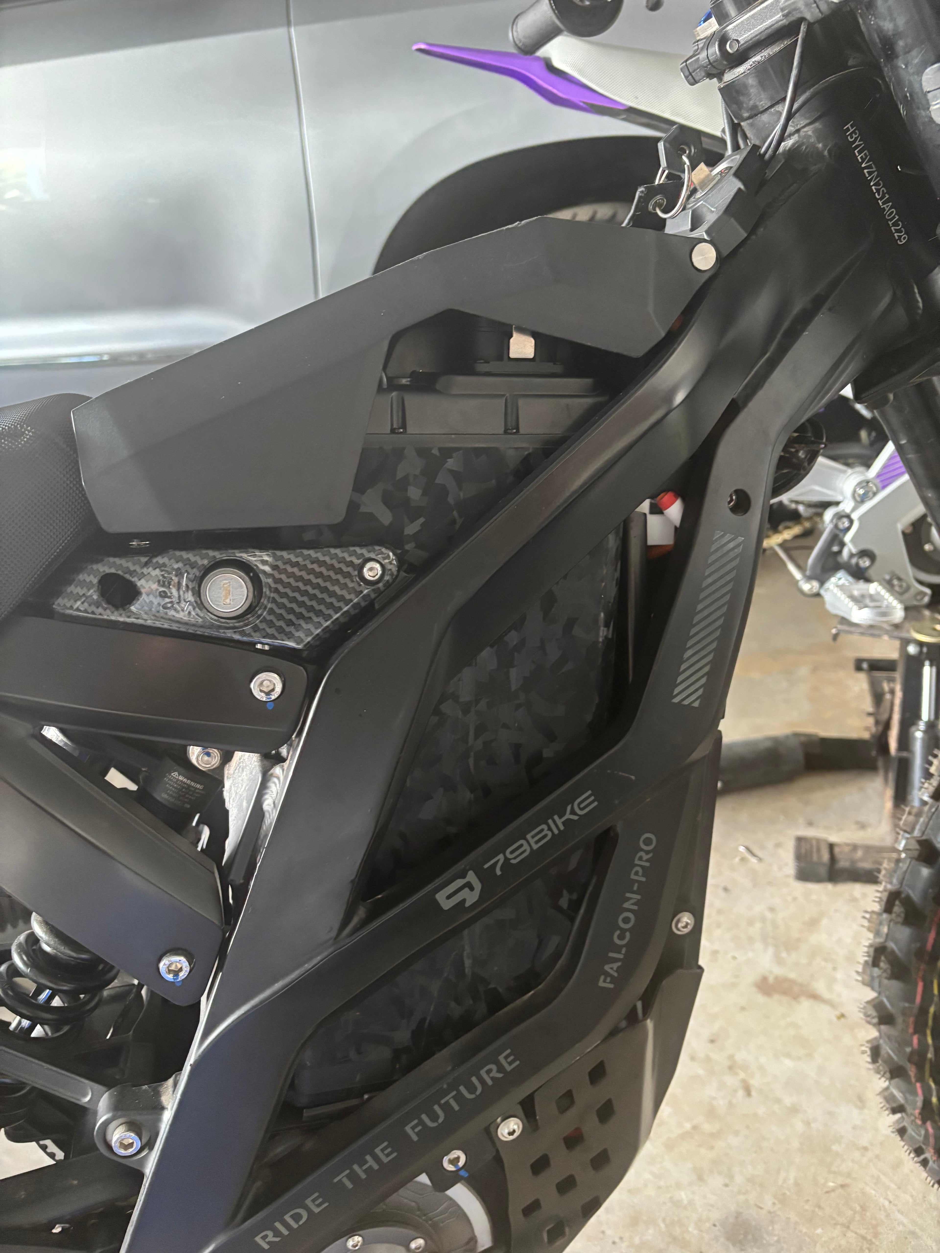 Forged carbon fiber battery wrap installed on a Sur-Ron battery cover